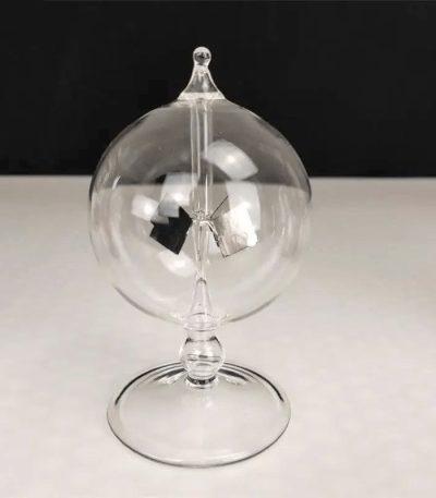 Transparent pendelboll i glas med hängande mekanism, elegant vetenskaplig dekoration, på svart och vit bakgrund.