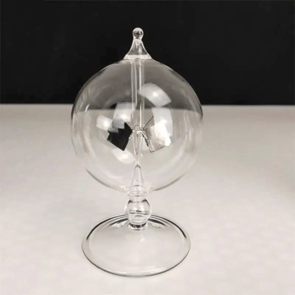 Transparent pendelboll i glas med hängande mekanism, elegant vetenskaplig dekoration, på svart och vit bakgrund.