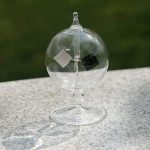 Transparent glasboll hängande med metallstöd, används för vetenskapliga experiment eller som vetenskaplig dekoration.