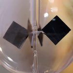 Vetenskaplig hänge i glas med magnet och hängande svart kub, som illustrerar ett fysik- eller kemiexperiment. Perfekt för dekoration eller samling av vetenskapliga objekt.