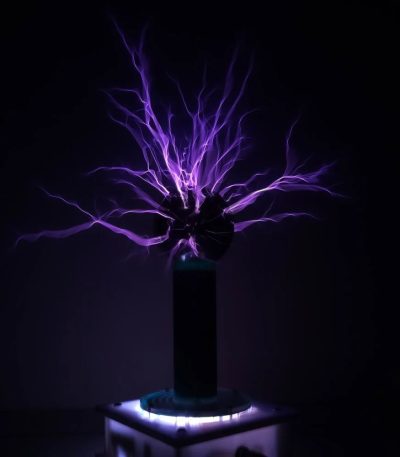 Illustration av en lila statisk elektrisk urladdning som kommer från en sfär, utställd i en mörk miljö, som representerar ett vetenskapligt experiment eller ett elektriskt fenomen.