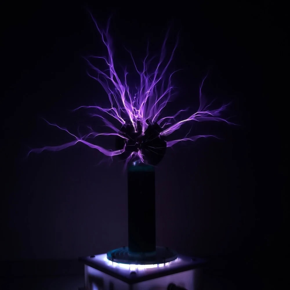 Illustration av en lila statisk elektrisk urladdning som kommer från en sfär, utställd i en mörk miljö, som representerar ett vetenskapligt experiment eller ett elektriskt fenomen.
