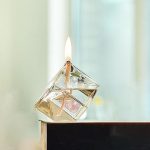 Rökelsehållare i kubform av glas med tänd låga, idealisk för vetenskaplig och modern inredning.