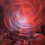 Ljusande kosmisk virvel projicerad på en inomhusvägg, vilket skapar en hypnotisk visuell effekt med varma och kalla färger. Perfekt för inredning inspirerad av universum och vetenskap.