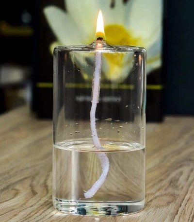 Tänd ljus med synlig veke i ett glas vatten, som skapar en intressant visuell effekt. Perfekt för vetenskaplig inredning eller som samlarobjekt.