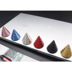Färgglada metallpyramider i aluminium, placerade på en vit yta, perfekta för dekoration eller vetenskaplig undervisning.