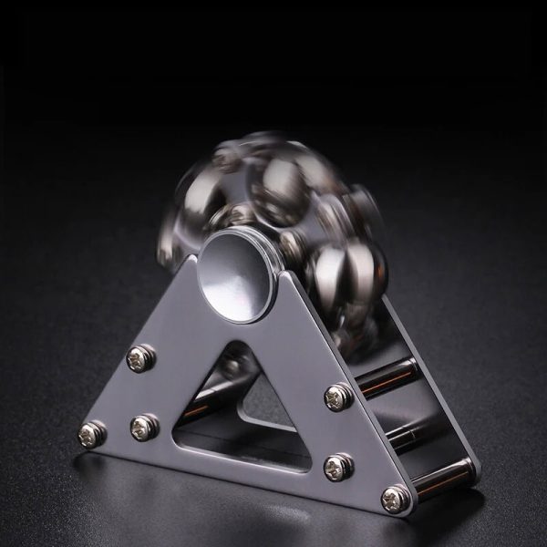 Pyramid av metallkulor i balans på en metallbas, som illustrerar ett fysikaliskt fenomen eller vetenskaplig experiment.