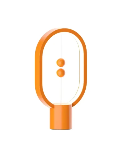 Modern skrivbordslampa i orange oval form med två knappar i mitten, perfekt för vetenskaplig eller modern dekoration.