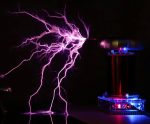 Lila plasmaurladdning genererad av en vetenskaplig anordning med synlig elektrisk urladdning i mörkret.