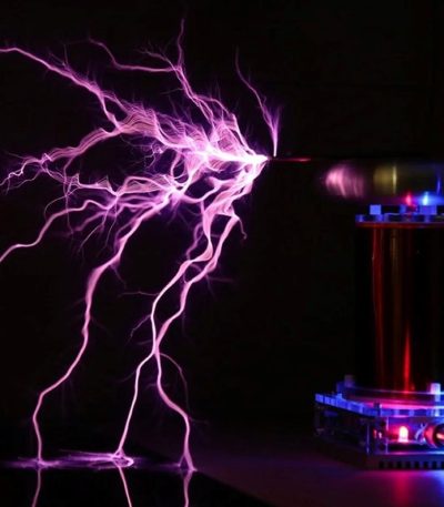 Lila plasmaurladdning genererad av en vetenskaplig anordning med synlig elektrisk urladdning i mörkret.