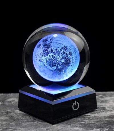 Dekorativ lampa i form av en måne med blå belysning, idealisk för vetenskaplig eller kosmisk inredning, som ger en modern och mystisk atmosfär i ditt hem.