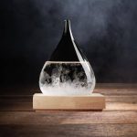 Glasvas med klart vätska och bubblor, placerad på en träbas, med en mörk bakgrund.