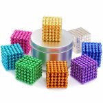Set av färgglada magnetiska kuber i stål, används som byggleksaker eller dekoration, med en gyllene kub placerad på en metallställning.