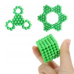 Par av 3D-molekylära modeller i form av triskel och stjärna, med en hand som håller en kub av gröna kulor. Idealisk för vetenskapligt lärande och pedagogisk dekoration.