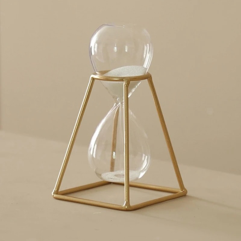 Tidsbärare i glas med gyllene ram, elegant och modern vetenskaplig dekoration, idealisk för älskare av industriell design och vetenskapsinspirerade dekorationsobjekt.