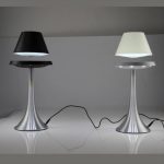 Modern skrivbordslampa med svart och vit skärm, bas i silvermetall, idealisk för en elegant och funktionell arbetsmiljö.