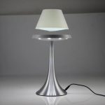Designad skrivbordslampa i silvermetall med vit skärm, idealisk för elegant och funktionell belysning i en arbets- eller läsmiljö.