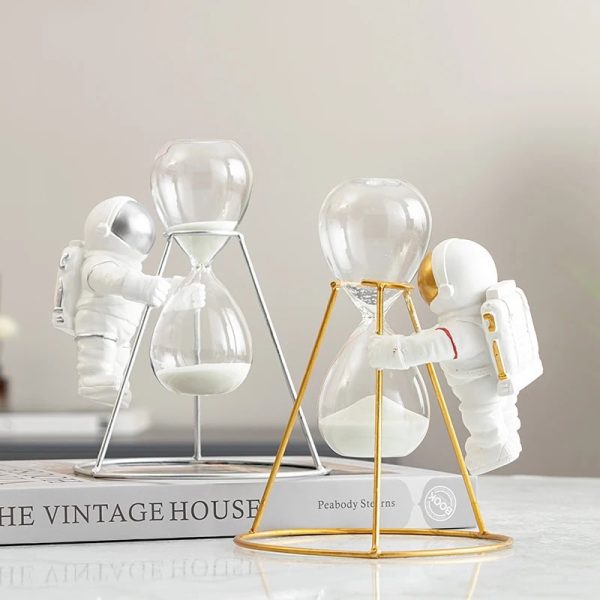 Skapa en originaldekoration med dessa astronautfigurer som hanterar sandur i glas, som symboliserar tid och rymdutforskning.