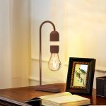 Designad skrivbordslampa i form av en glödlampa med stöd i naturligt trä, idealisk för vetenskaplig eller modern inredning.
