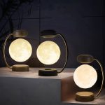 Bordslampa i form av en måne med varmt ljus, idealisk för vetenskaplig eller modern inredning.