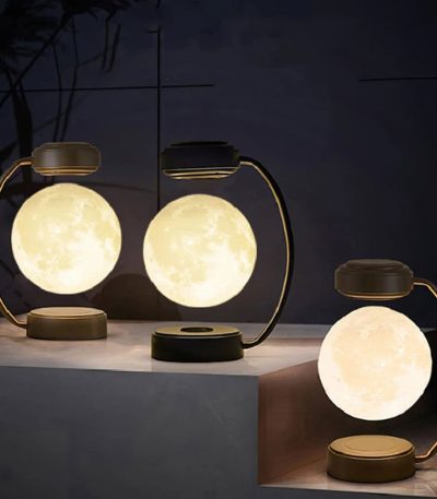 Bordslampa i form av en måne med varmt ljus, idealisk för vetenskaplig eller modern inredning.