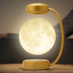 Dekorativ månlampa med gyllene stöd, som skapar en varm och mystisk atmosfär i ditt hem. Idealisk för en originell och elegant inredning, inspirerad av astronomi och vetenskap.