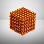 Glänsande orange metallkula som bildar en 3D-pyramid, illustrerande en vetenskaplig eller dekorativ modell.