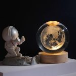 Ljusglob som föreställer månen med en plastastronautfigur, vetenskaplig inredning för inomhusbruk, rymd- och utbildningsinspirerad atmosfär.