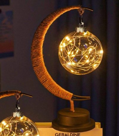 Månlampa med en glasboll belyst av varma LED-lampor, som skapar en varm och sagolik atmosfär.