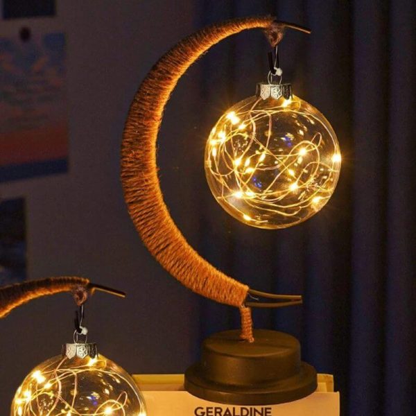 Månlampa med en glasboll belyst av varma LED-lampor, som skapar en varm och sagolik atmosfär.