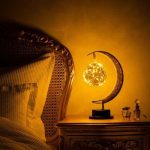 Dekorativ lampa i form av en måne och en stjärnglob, idealisk för vetenskaplig och elegant inredning i ett sovrum eller vardagsrum.