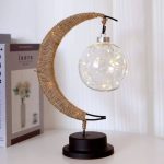 Dekorativ taklampa i form av en måne med en ljusslinga i glas, perfekt för en originell och elegant inredning.