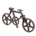 Nyckelring eller dekorationsobjekt i form av cykel i metall, idealisk för vetenskaps- och industriell designentusiaster.