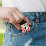Utbildande kubspel med siffror och symboler i fickan på ett par jeans, som illustrerar ett lekfullt och utbildande vetenskapligt föremål.