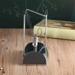 Newtonpendel i metall och glas, dekorativt vetenskapligt objekt för kontor eller klassrum.