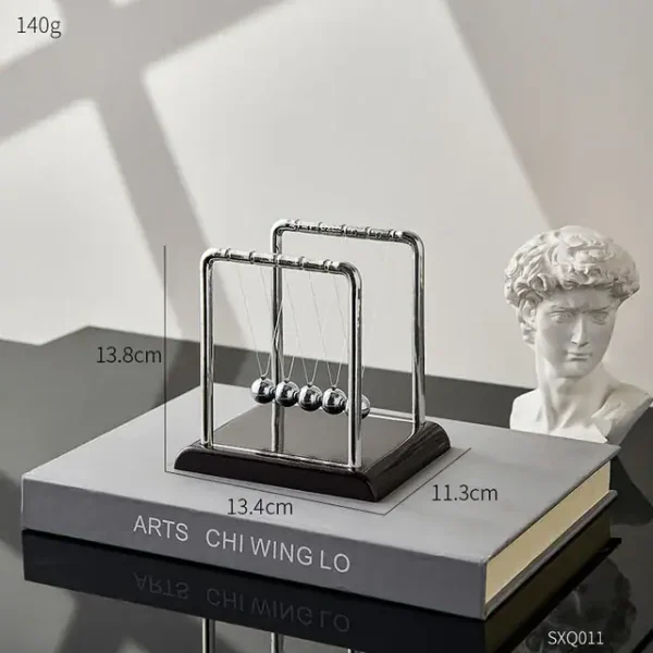 Newton-hänge i metall, inspirerat av det berömda Newtons kulexperiment, perfekt för kontors- eller hylldekoration med en vetenskaplig och modern stil.