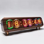 Vintage klocka med färgade Nixie-tuber i glas, inramad i ett trähus, som visar tiden 08:38:49, idealisk för retro- eller vetenskaplig dekoration.