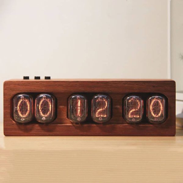 Vintage Nixie-klocka med digital visning i Nixie-rör, inramad i naturligt trä, tänd på en ljus träyta, retro och industriell stil.