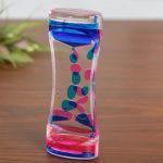 Transparent glasvas prydd med abstrakta mönster i blått, rosa och transparent, idealisk för vetenskaplig eller modern inredning.