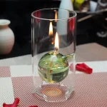 Ljushållare i glas som innehåller ett tänt ljus, perfekt för vetenskaplig eller laboratoriedekoration.