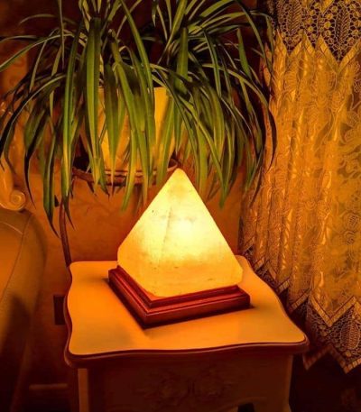 Pyramidformad lampa i naturlig sten, mjukt och dekorativt ljus för elegant inredning.