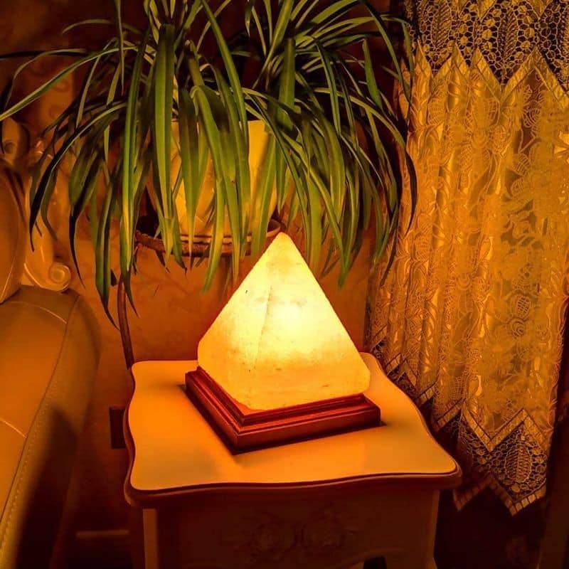 Pyramidformad lampa i naturlig sten, mjukt och dekorativt ljus för elegant inredning.