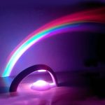 Lysande regnbåge med metallstativ och färgglad LED-belysning, som skapar en magisk och sagolik atmosfär i rummet.