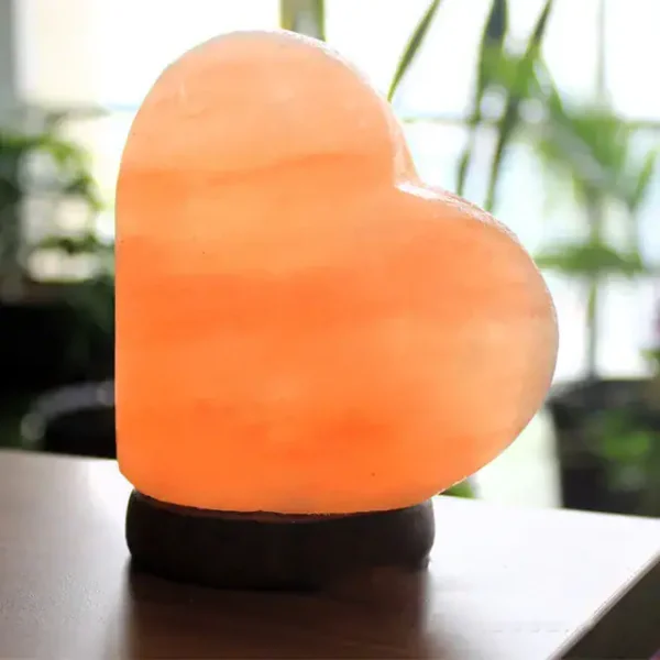 Hjärtlampa i naturlig sten, belyst för att skapa en varm och romantisk atmosfär. Perfekt för inredning eller som en originell present.