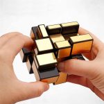 Person som hanterar en Rubik's kub, ett färgglatt 3D-pussel, för att stimulera sinnet och logik.
