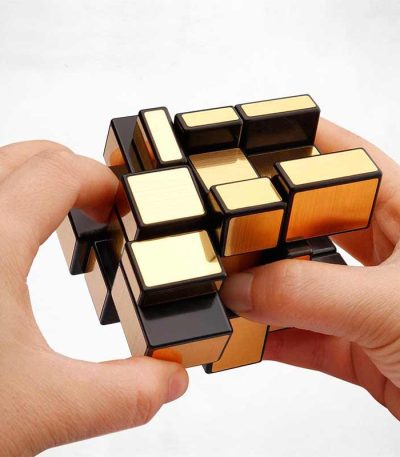 Person som hanterar en Rubik's kub, ett färgglatt 3D-pussel, för att stimulera sinnet och logik.