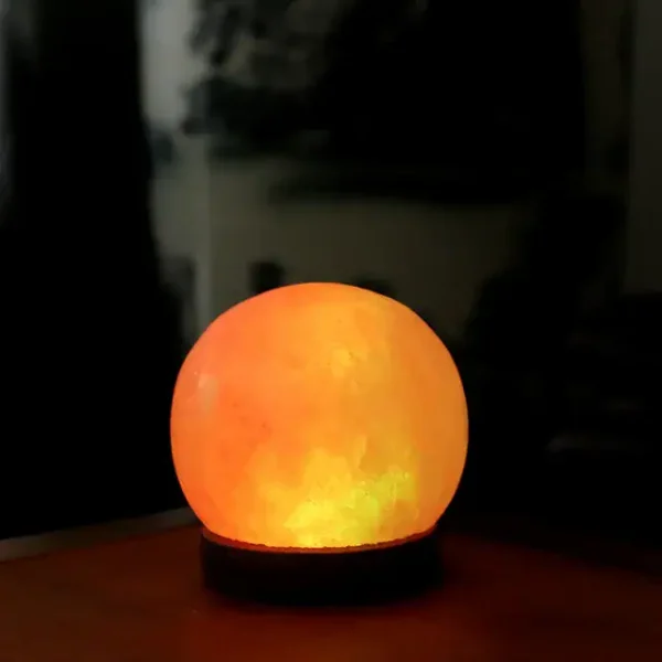 Himalayasaltmånlampa som avger ett varmt ljus, perfekt för inredning eller som en avslappnande nattlampa.