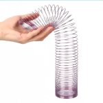 Spiralformad metallhänge hålls av en hand, som illustrerar ett vetenskapligt objekt för experiment eller dekoration.