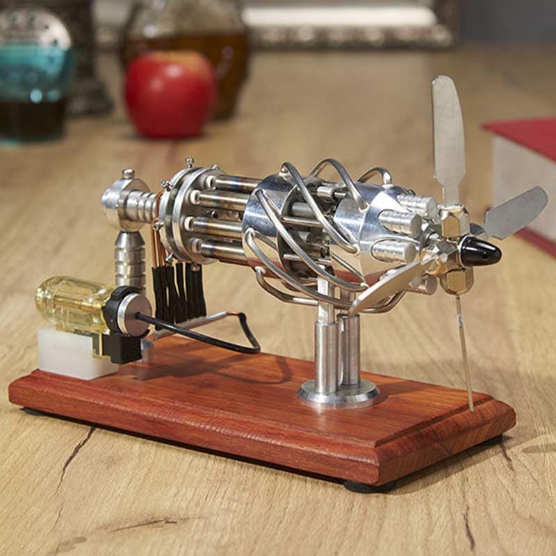 Modell av ångmotor i metall med propeller, monterad på en träbas, som illustrerar en miniatyrångmotor för dekoration eller vetenskaplig studie.