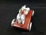 Miniatyr elektrisk motor i trä med metallkomponenter, idealisk för vetenskapliga eller pedagogiska projekt.